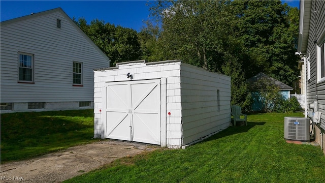 view of outbuilding featuring a yard and central AC unit