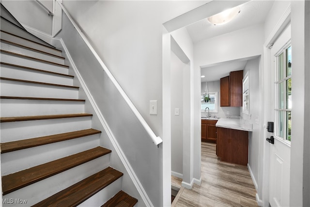 staircase with sink and wood-type flooring