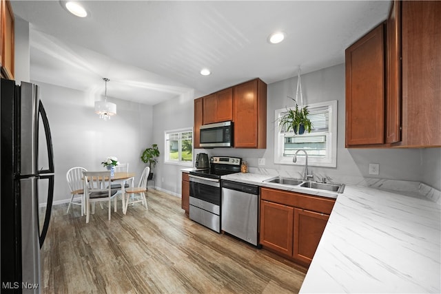 kitchen featuring lofted ceiling, stainless steel appliances, hardwood / wood-style flooring, sink, and pendant lighting