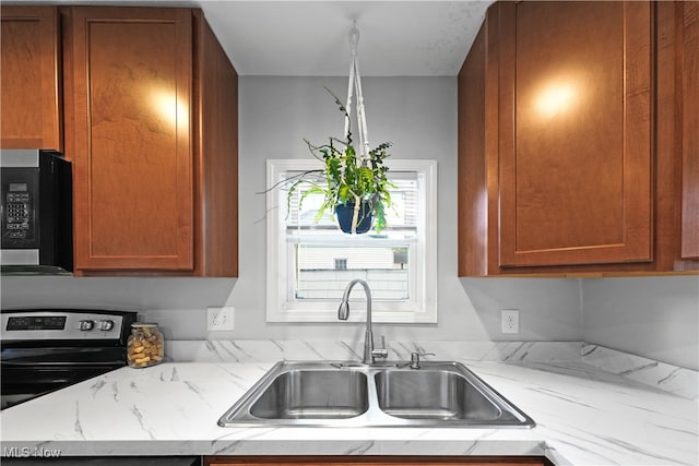 kitchen featuring light stone countertops, sink, and electric range oven