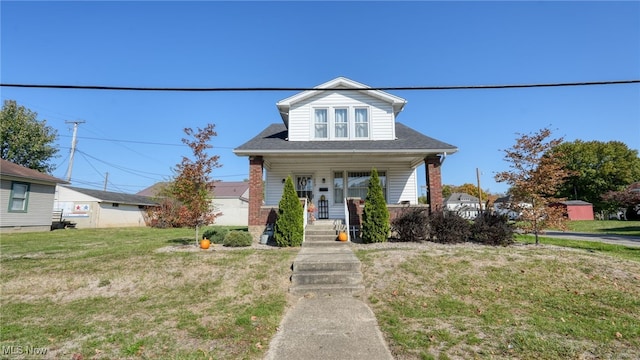 bungalow featuring a front yard, an outdoor structure, and a porch