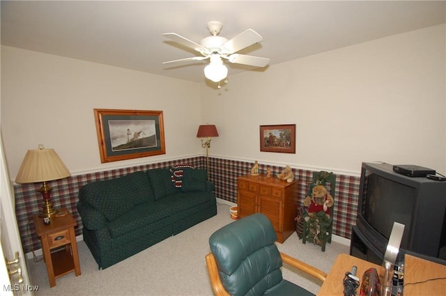 living area with carpet and ceiling fan