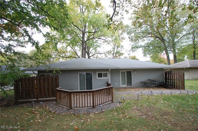 rear view of property featuring a yard and a deck