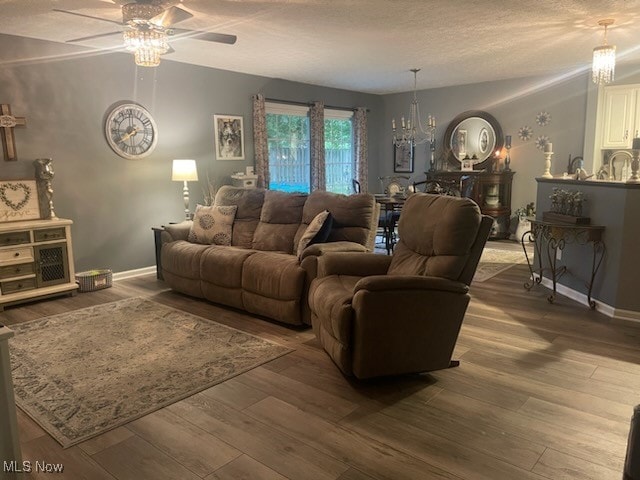 living room featuring a textured ceiling, hardwood / wood-style flooring, and ceiling fan with notable chandelier