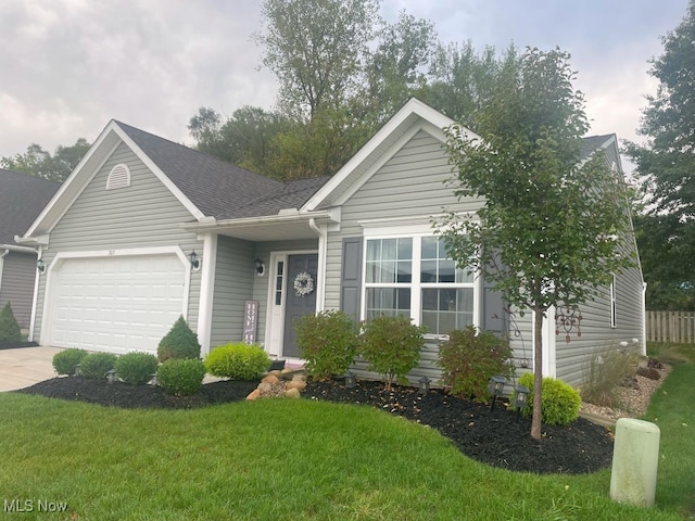 view of front of home with a front yard and a garage