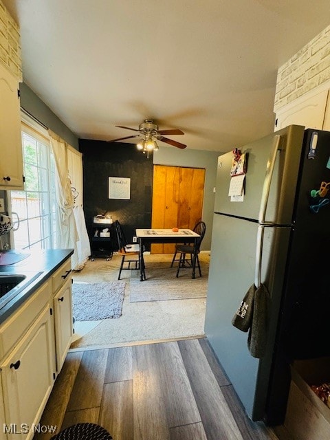 kitchen featuring ceiling fan, sink, light hardwood / wood-style floors, fridge, and cream cabinetry