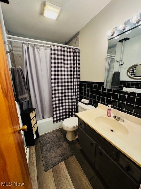 full bathroom with vanity, wood-type flooring, backsplash, shower / bathtub combination with curtain, and toilet