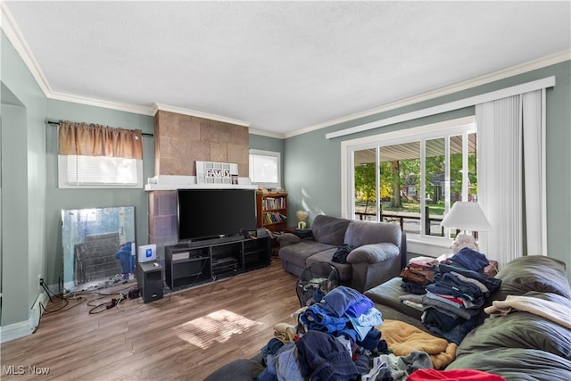 living room featuring ornamental molding, hardwood / wood-style floors, a textured ceiling, and a wealth of natural light