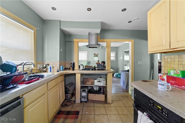 kitchen with island exhaust hood, stainless steel appliances, sink, light tile patterned floors, and tasteful backsplash