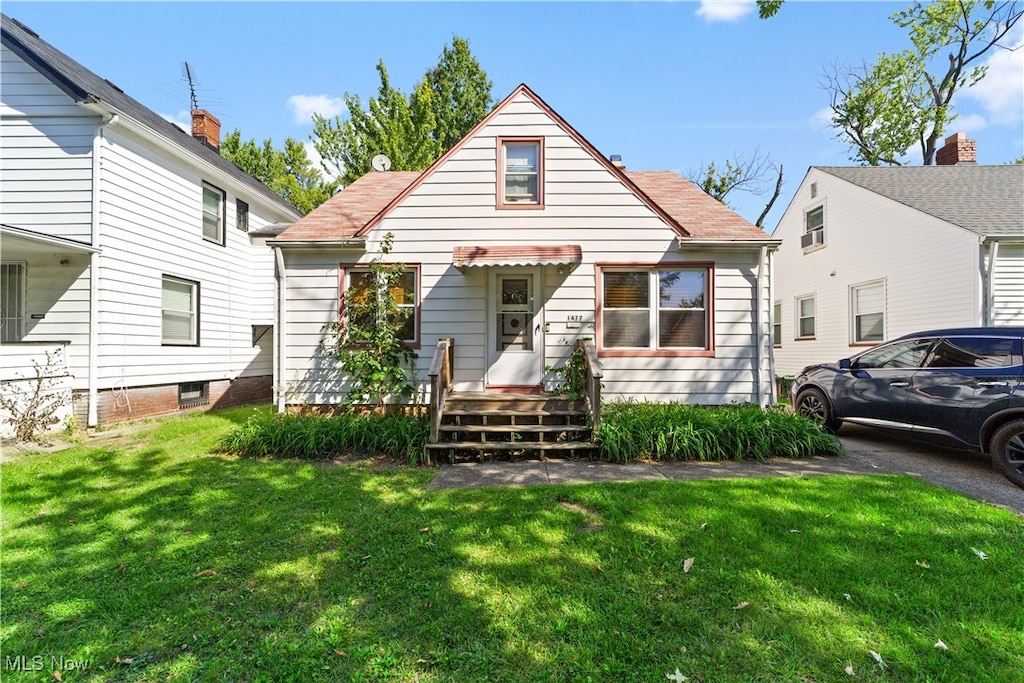 bungalow-style house featuring a front lawn