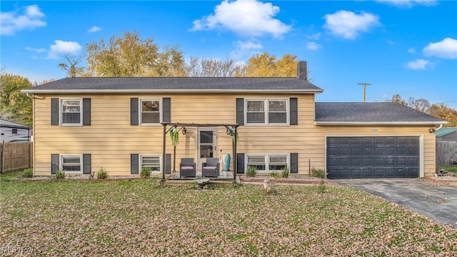 bi-level home featuring a garage and a front lawn