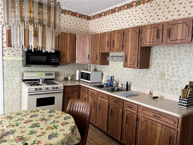 kitchen with sink, white appliances, light tile patterned floors, and a textured ceiling