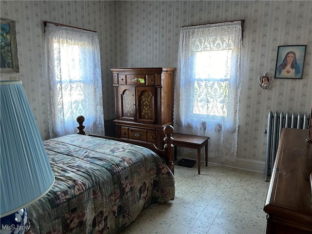 bedroom featuring radiator heating unit and multiple windows