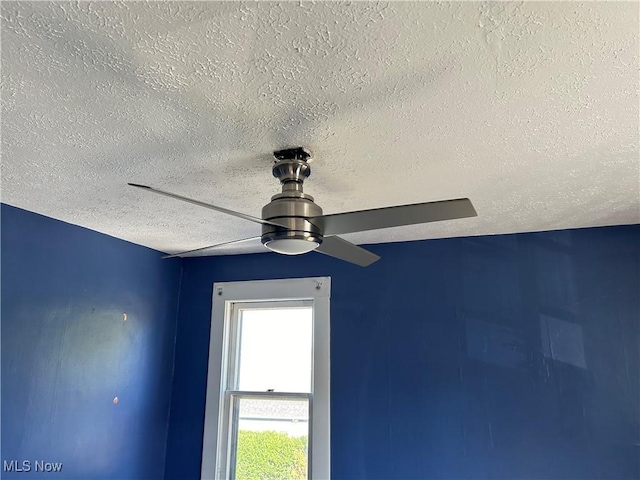 room details featuring ceiling fan and a textured ceiling