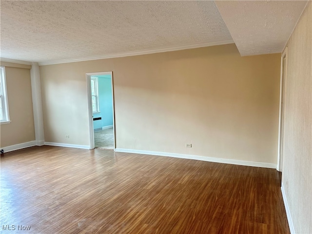 empty room with a textured ceiling, crown molding, and hardwood / wood-style floors