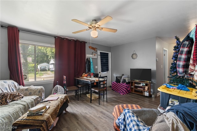 living room featuring dark wood-type flooring and ceiling fan