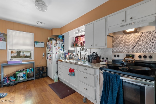 kitchen featuring white cabinets, stainless steel electric range oven, light hardwood / wood-style flooring, sink, and white refrigerator