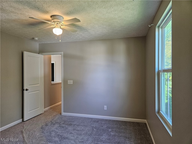 unfurnished room with a textured ceiling, carpet, and ceiling fan