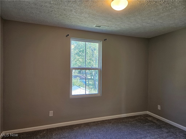 carpeted empty room with a textured ceiling