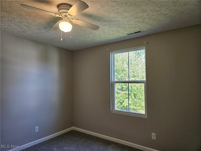 carpeted spare room with a textured ceiling and ceiling fan