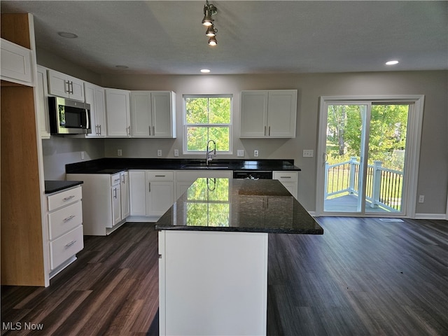 kitchen featuring sink, a wealth of natural light, a kitchen island, and white cabinets