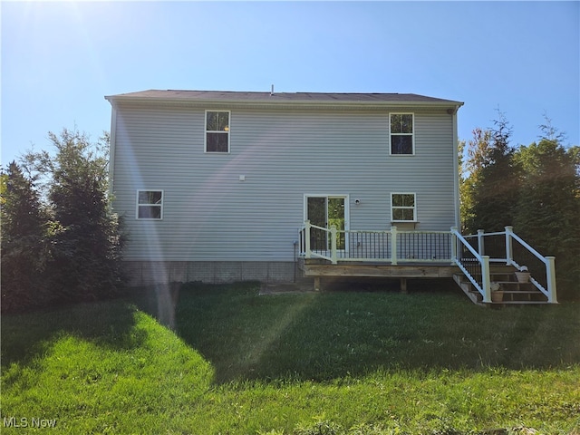 rear view of property with a wooden deck and a lawn