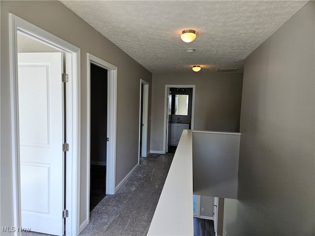 hallway featuring dark wood-type flooring and a textured ceiling