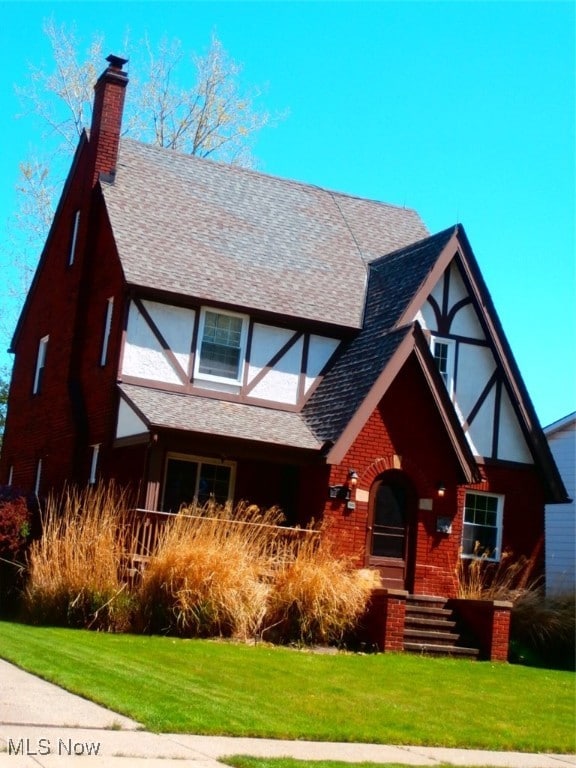 tudor home featuring a front lawn