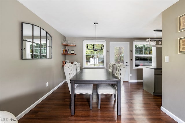 dining space featuring dark hardwood / wood-style floors and a chandelier