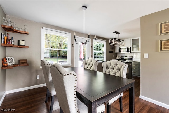 dining area featuring dark wood-type flooring and a notable chandelier