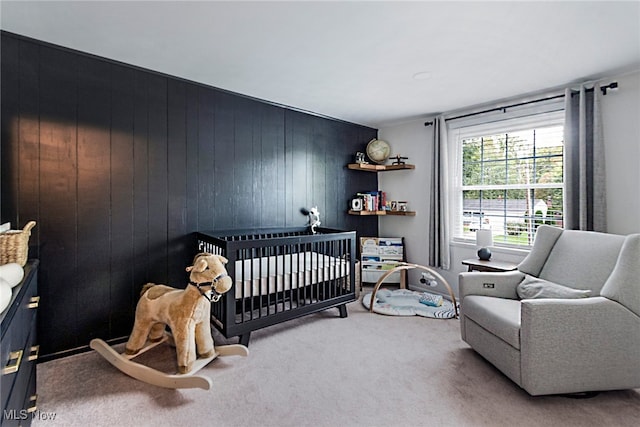 carpeted bedroom with wood walls and a nursery area