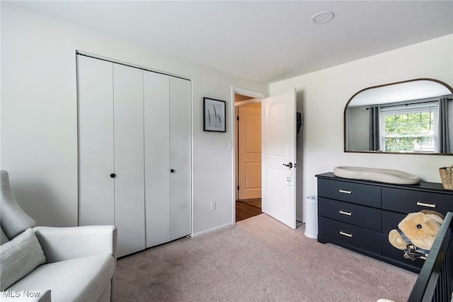 bedroom with light carpet and a closet