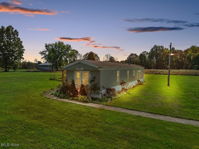 property exterior at dusk with a yard