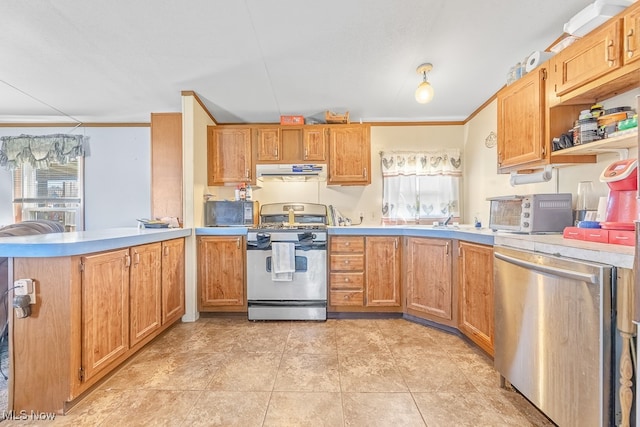 kitchen with a healthy amount of sunlight, stainless steel appliances, ornamental molding, and kitchen peninsula