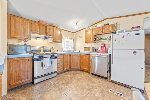 kitchen with lofted ceiling, appliances with stainless steel finishes, and light tile patterned floors