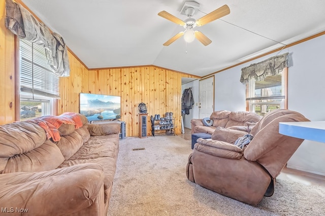 living room featuring ornamental molding, vaulted ceiling, ceiling fan, and wood walls