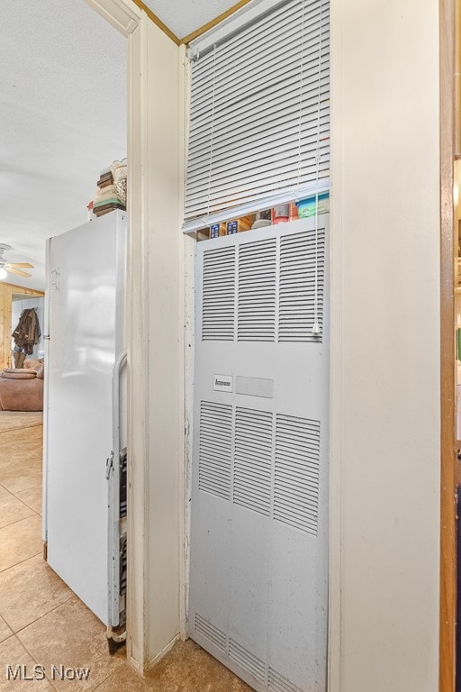 room details featuring white fridge, ceiling fan, and tile patterned flooring