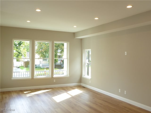 unfurnished room featuring light hardwood / wood-style floors and a wealth of natural light