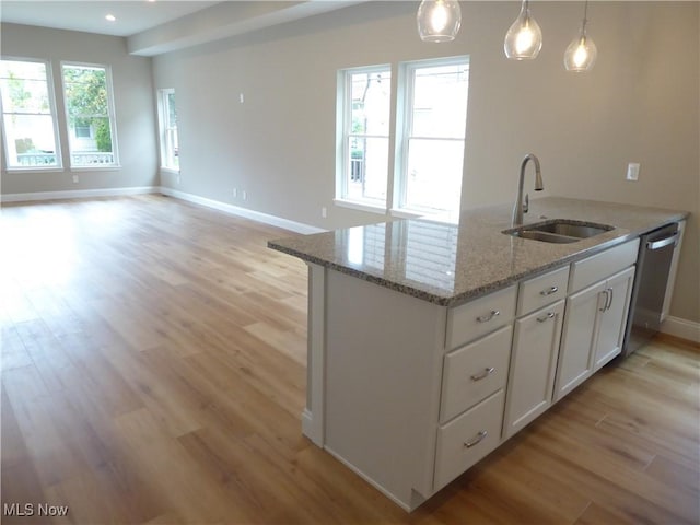 4424 W 53rd St, Cleveland, OH 44109 - kitchen featuring a sink, light wood-style flooring, white cabinetry, baseboards, and dishwasher