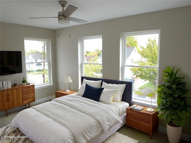 4424 W 53rd St, Cleveland, OH 44109 - bedroom with multiple windows, baseboards, wood finished floors, and a ceiling fan