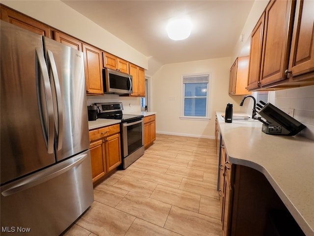 kitchen with appliances with stainless steel finishes, sink, and backsplash