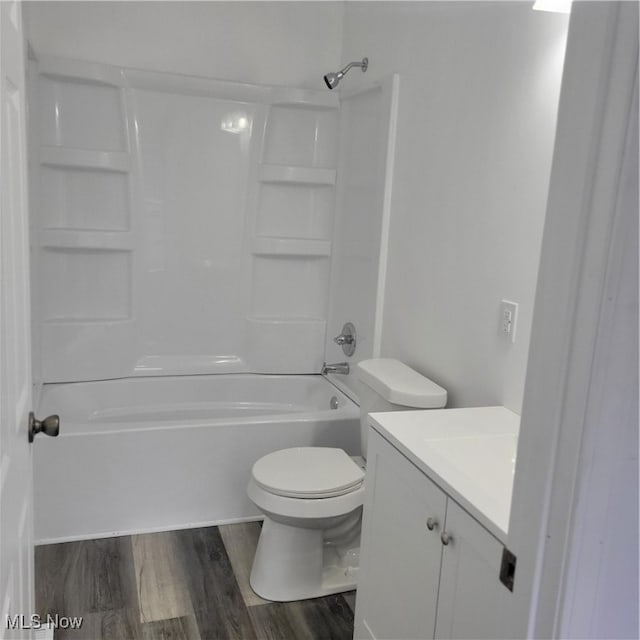 full bathroom with toilet, vanity, wood-type flooring, and washtub / shower combination