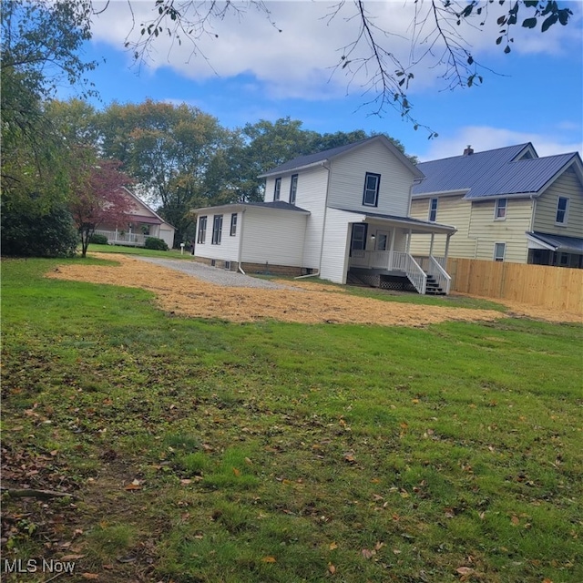 rear view of house with a yard and covered porch