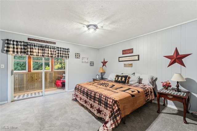 bedroom with a textured ceiling, wooden walls, and carpet flooring