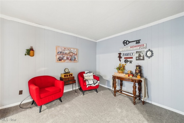 sitting room with ornamental molding, carpet floors, and wooden walls