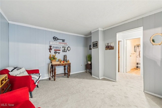 sitting room with light carpet, ornamental molding, and wooden walls