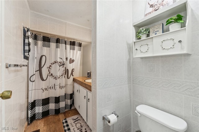 bathroom featuring toilet, tile walls, walk in shower, vanity, and hardwood / wood-style flooring