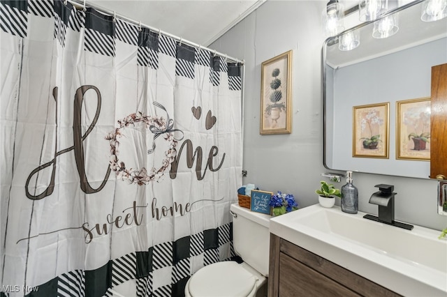 bathroom featuring vanity, toilet, ornamental molding, and curtained shower