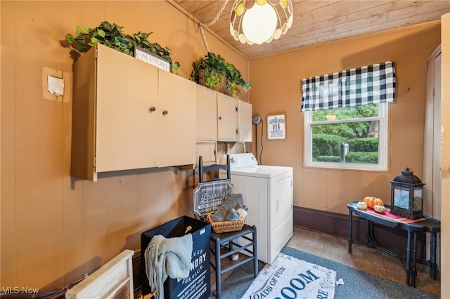 laundry room with wooden walls, wood ceiling, cabinets, and washer / clothes dryer