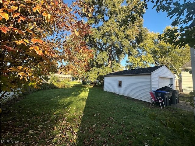 view of yard with a garage and an outbuilding